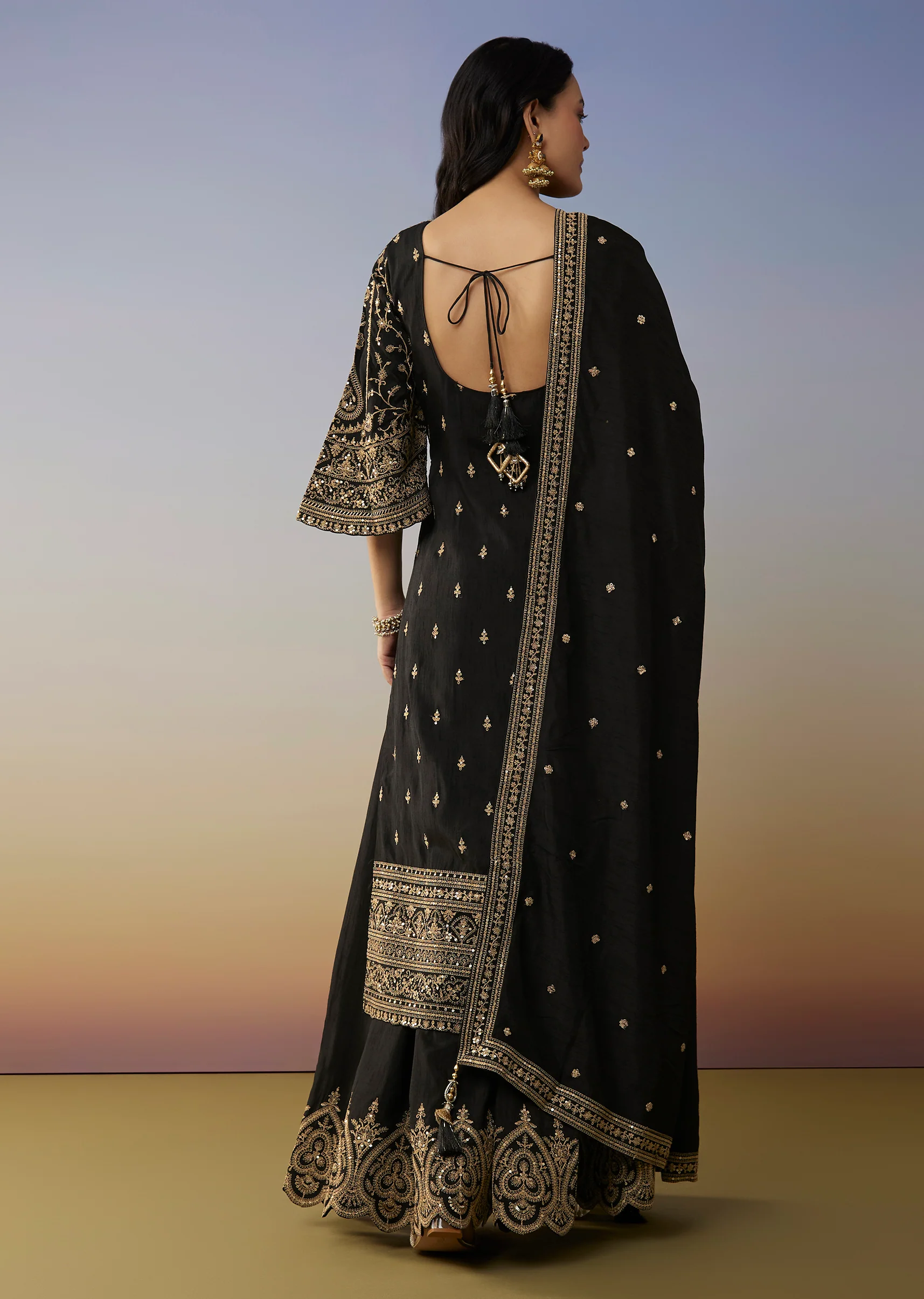 Bold Festive Couple Set – Black Silk Palazzo Suit With Zari Thread And Sequins Work For Her And Black Suiting Jodhpuri Pant Set With Embroidery For Him - Image 5